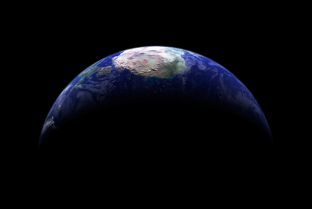 A photo of earth from space, the top third lit with sun, with the bottom in darkness